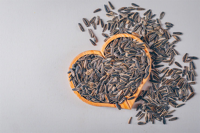 photo of black sunflower seeds on a heart-shaped board