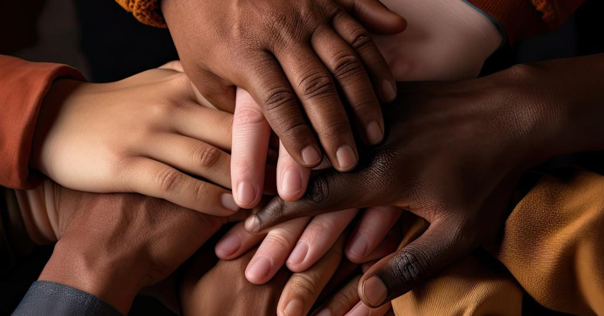 Photo of hands with different skin tones on top of one another.